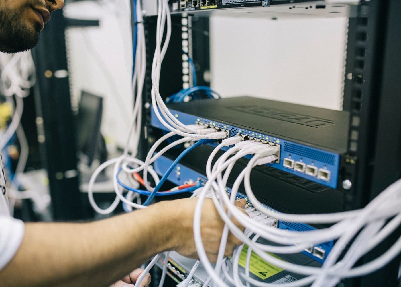 Technician terminating structured cabling in a network rack